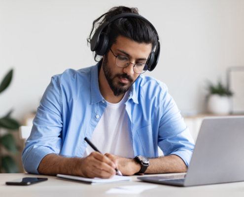 Guy In Headphones Studying With Laptop At Home